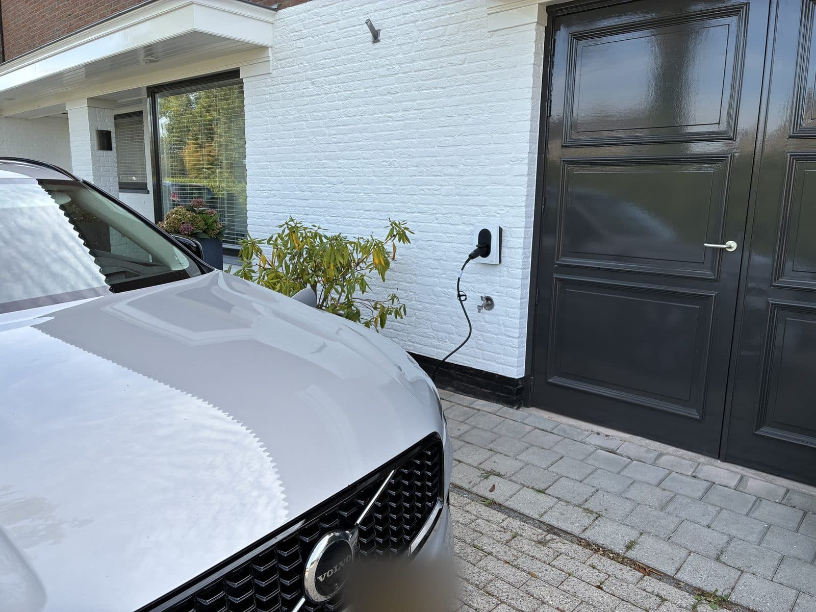 Elektrische auto aan de laadpaal bij een woonhuis, geïnstalleerd door Grow Green Energy