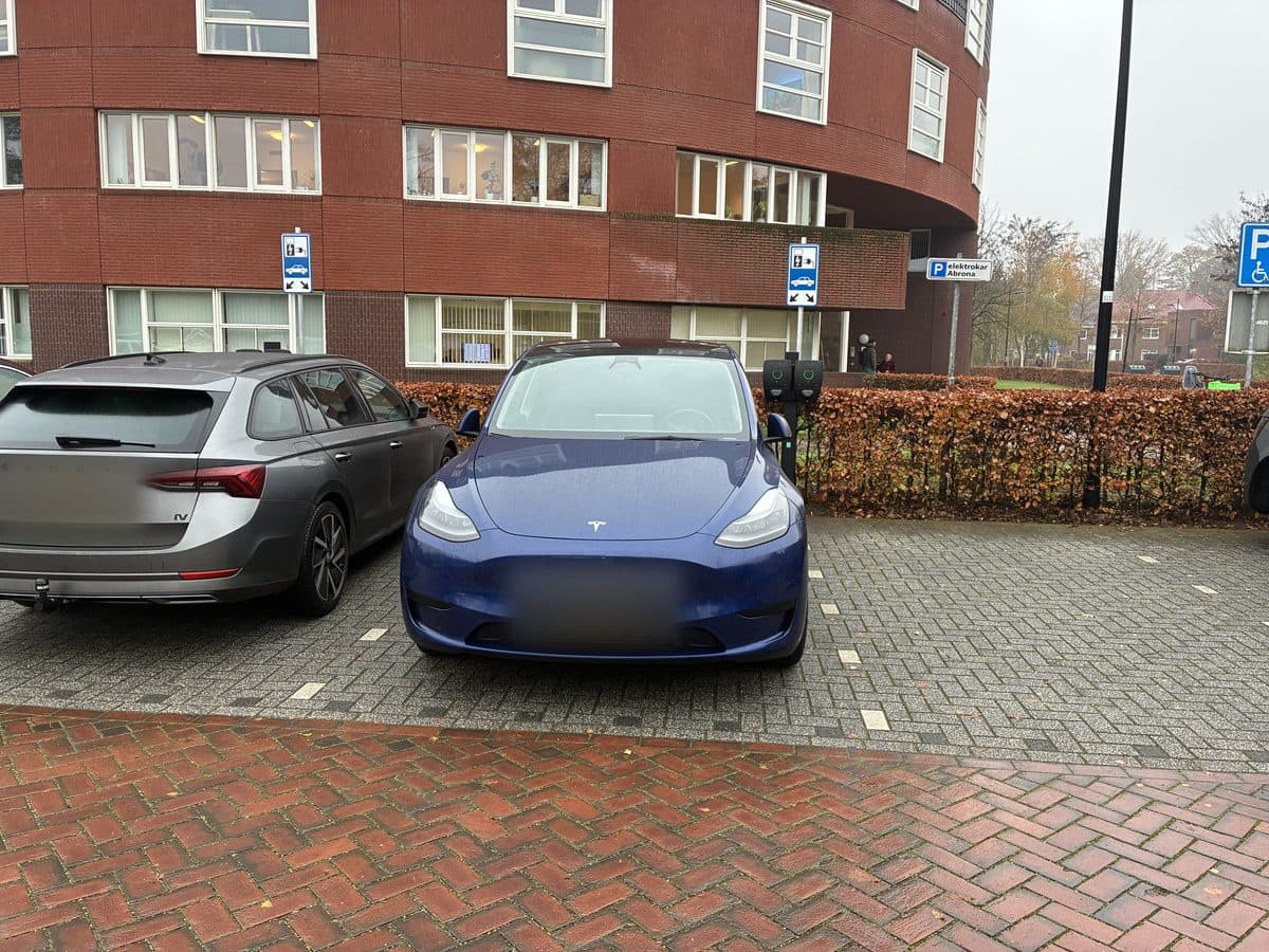Laadpunten op de parkeerplaats van een appartementencomplex, met auto's aan de lader
