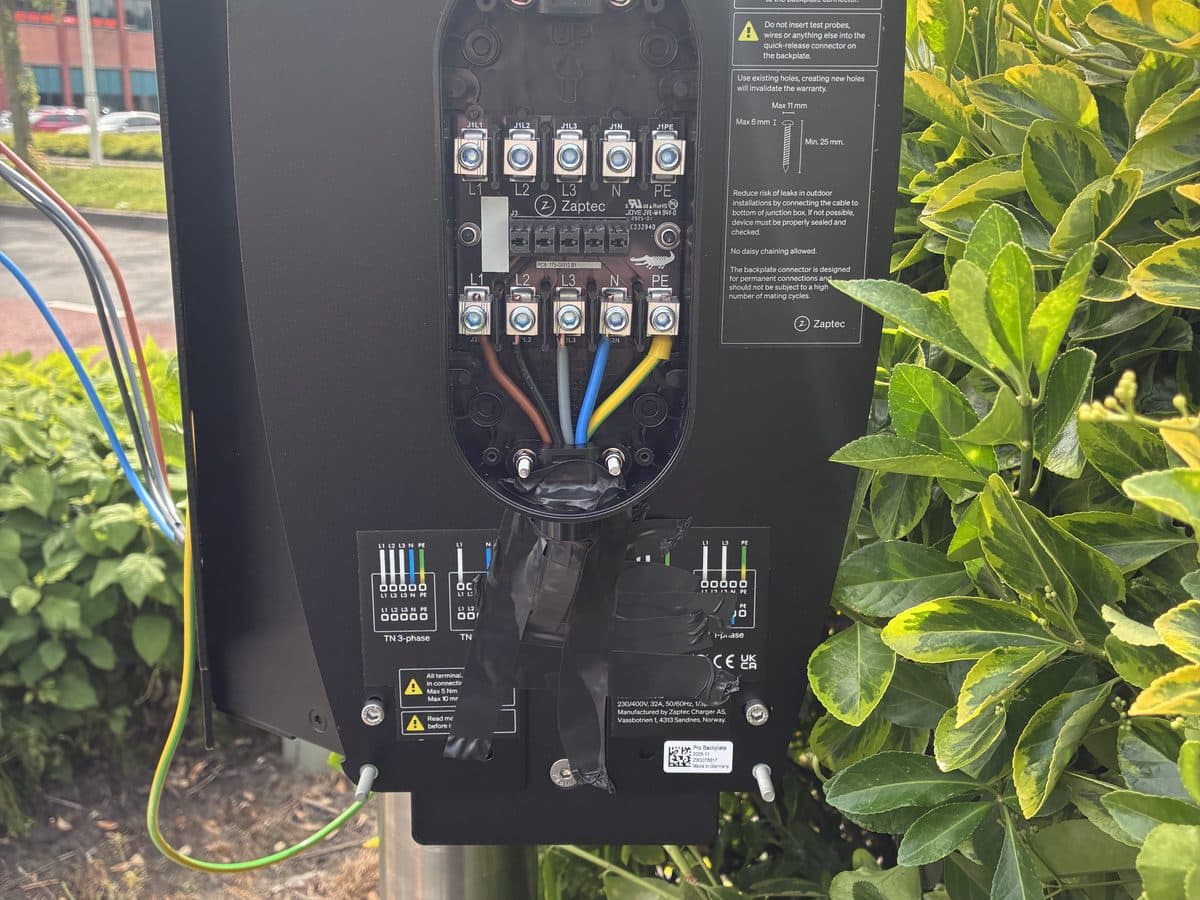 Geopende laadpaal tijdens de installatie, met de aansluiting in beeld